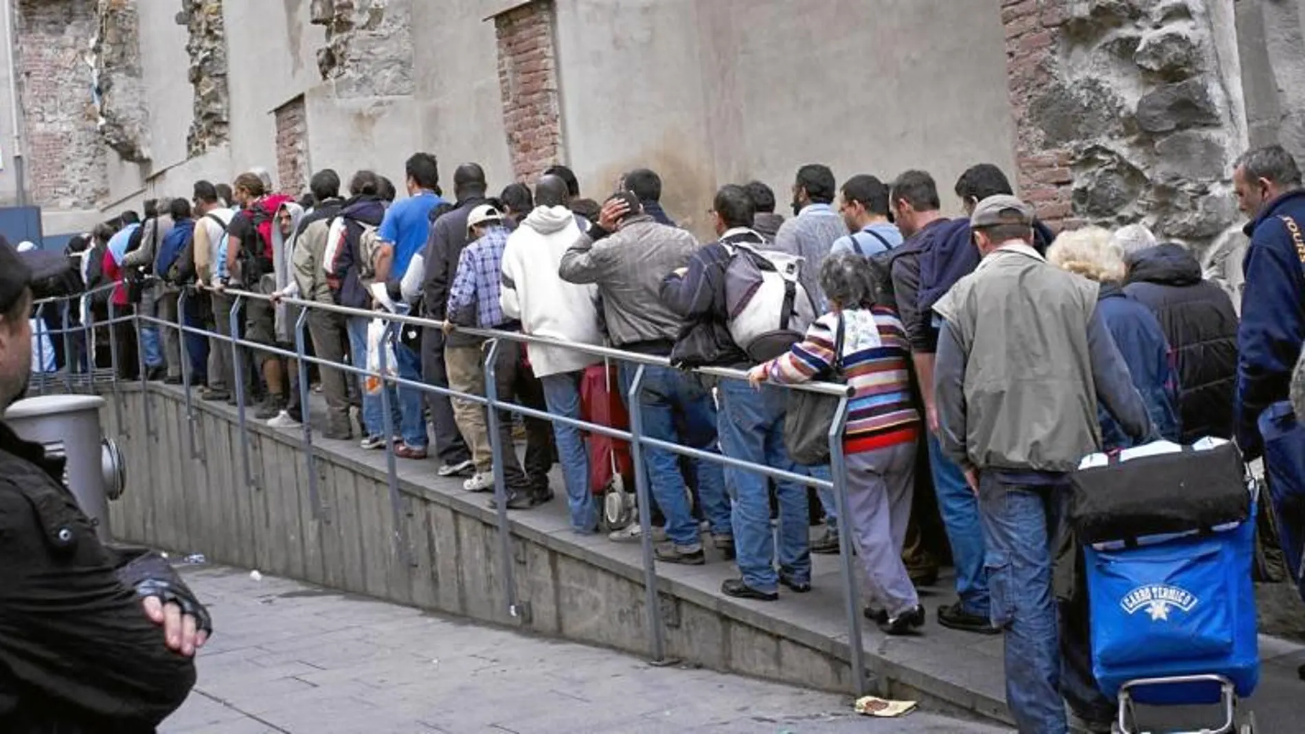 Imagen de gente que hace cola para recibir una comida caliente en Sant Agustí