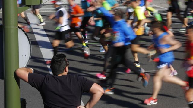 Un espectador observa a los corredores del maratón de Madrid de 2016
