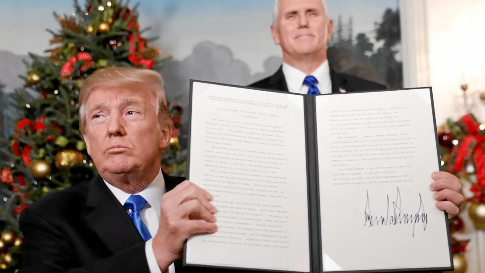 Trump muestra su firma en el documento en el que se decide el traslado de la embajada