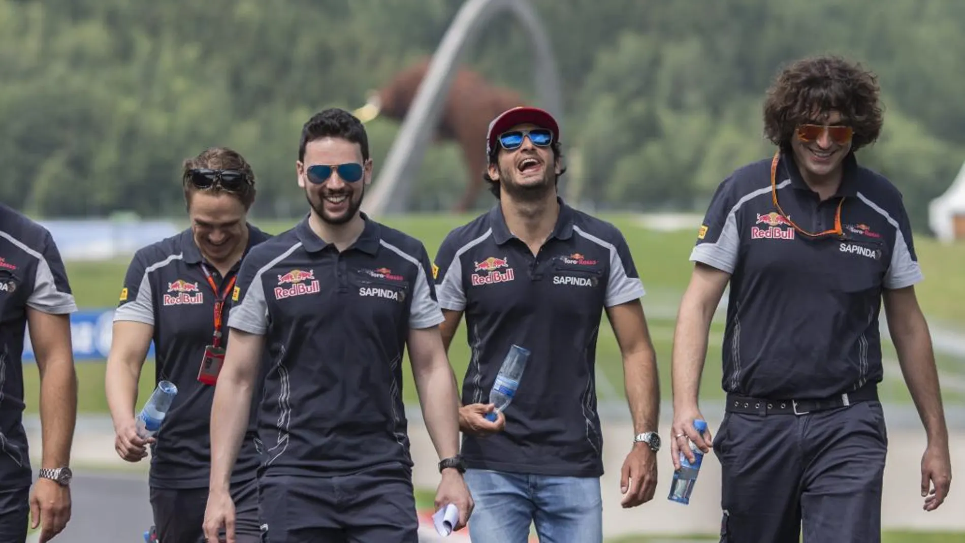 El piloto español de Fórmula Uno Carlos Sainz (2º dcha), de Toro Rosso, inspecciona la pista mientras prepara su participación en el Gran Premio de Austria de Fórmula Uno en Spielberg (Austria)