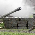 Un soldado armenio se protege del ruido de la explosión de un cañón en el enclave de Nagorno Karabaj