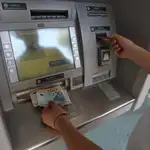Un cliente retira dinero en un cajero