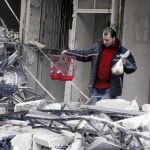 Un sirio saca una jaula tras los bombardeos de Asad en un barrio al norte de Alepo, ayer