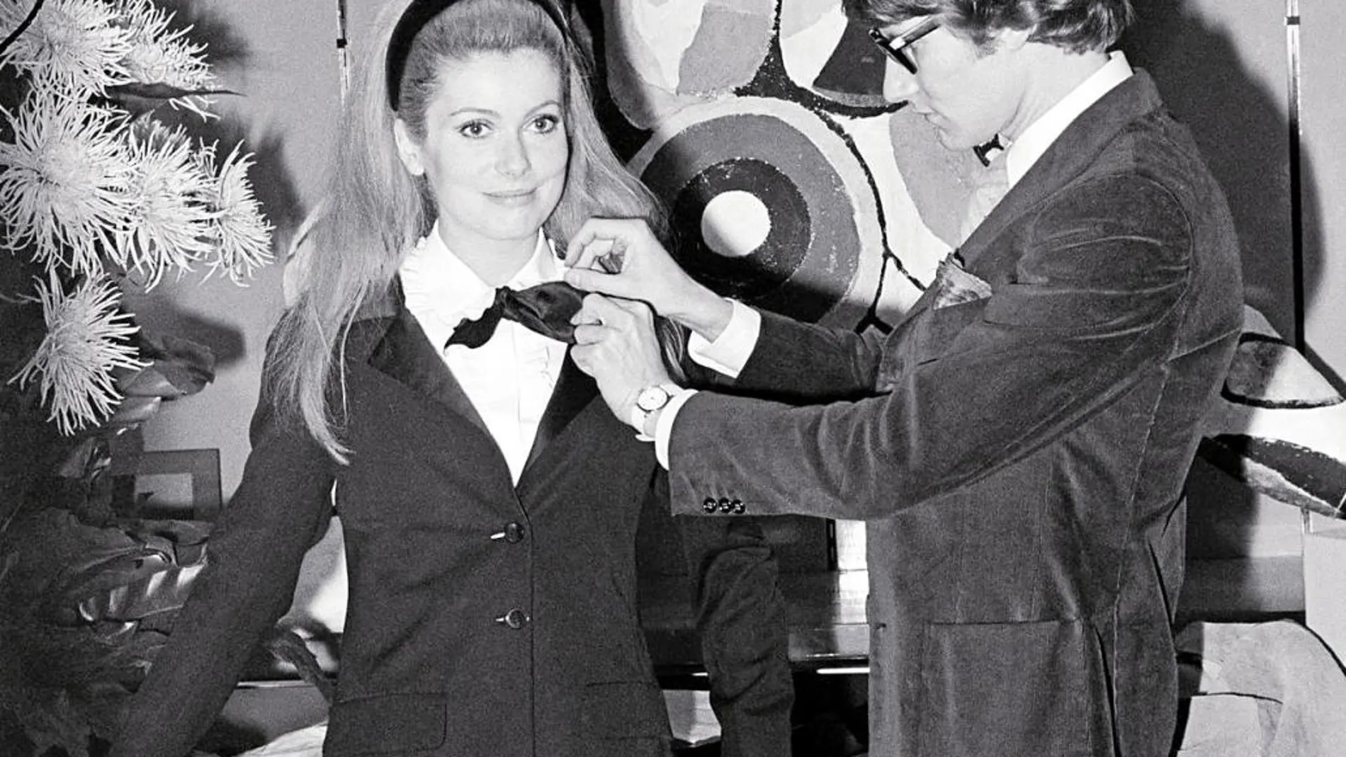 Yves Saint Laurent, en 1967, junto a una joven Catherine Deneuve, que lucía su smoking