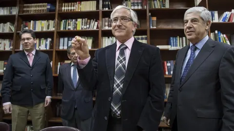 El secretario de la Audiencia de Sevilla, Luis Revilla, muestra la bola con el número de la Sala durante el sorteo