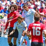 Varane y Modric disputan un balón aéreo con Fellaini