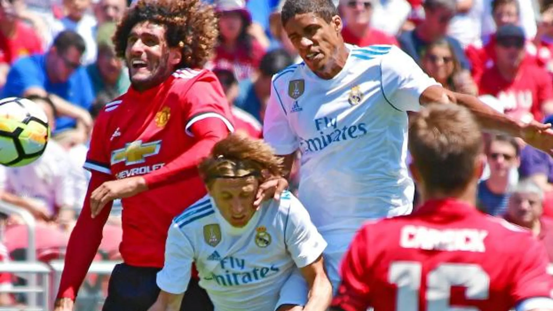 Varane y Modric disputan un balón aéreo con Fellaini