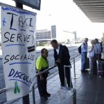 Varios viajeros del aeropuerto del Prat (Barcelona) esperan en vano la llegada de un taxi
