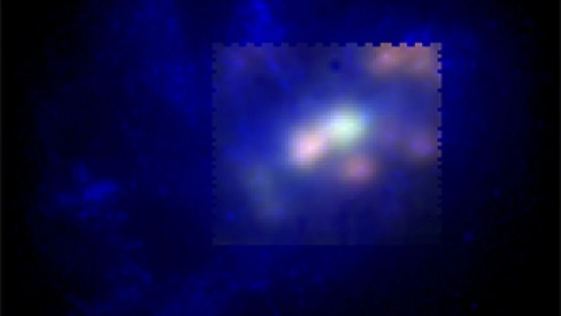 Imagen de falso color de la galaxia UCM2325+2318. En verde y rojo se muestra la emisión del nitrógeno y del hidrógeno presentes, respectivamente, en el gas caliente (10,000 grados) de esta galaxia. En azul se muestra la emisión de las estrellas a partir de una imagen del Telescopio Espacial Hubble.