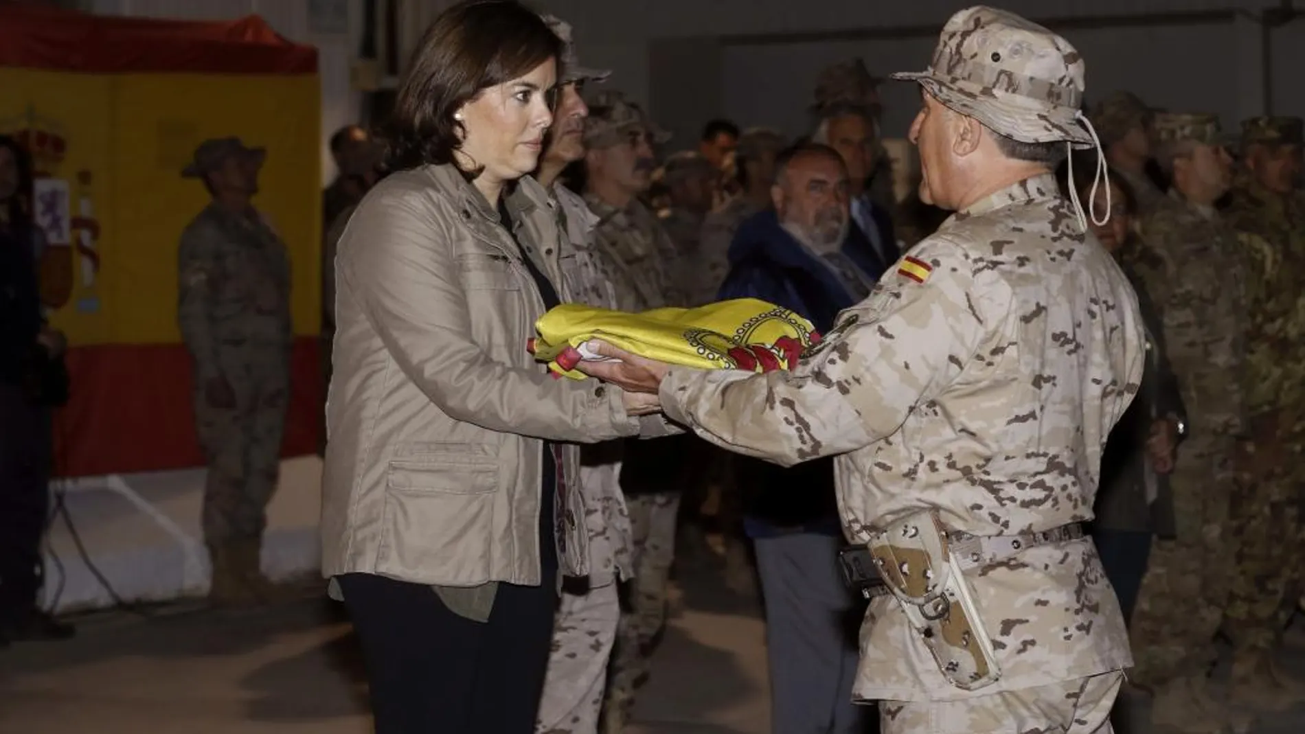 Soraya Sáenz de Santamaría recibe la bandera de manos del jefe del contingente español, coronel Francisco José García Parra, en el acto de despedida de las tropas españolas destinadas en la base de Herat