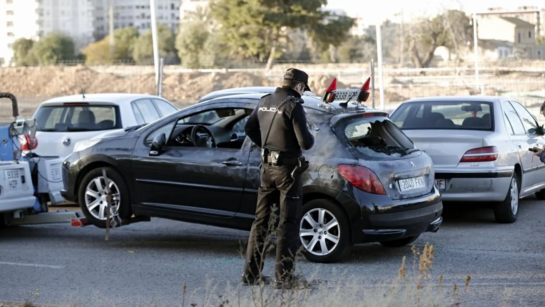 Un agente de policía toma la matrícula del coche en el que circulaba el hombre que ha muerto apuñalado junto al nuevo hospital La Fe de Valencia