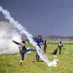 Los refugiados tratan de protegerse de los gases lacrimógenos en Idomeni