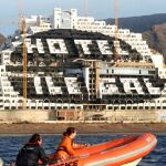 Dos activiostas de Greenpeace pasan en una lancha por delante del hotel