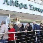 Chipriotas hacen cola para entrar en una sucursal del banco Coop, en Nicosia, hoy, jueves 28 de marzo