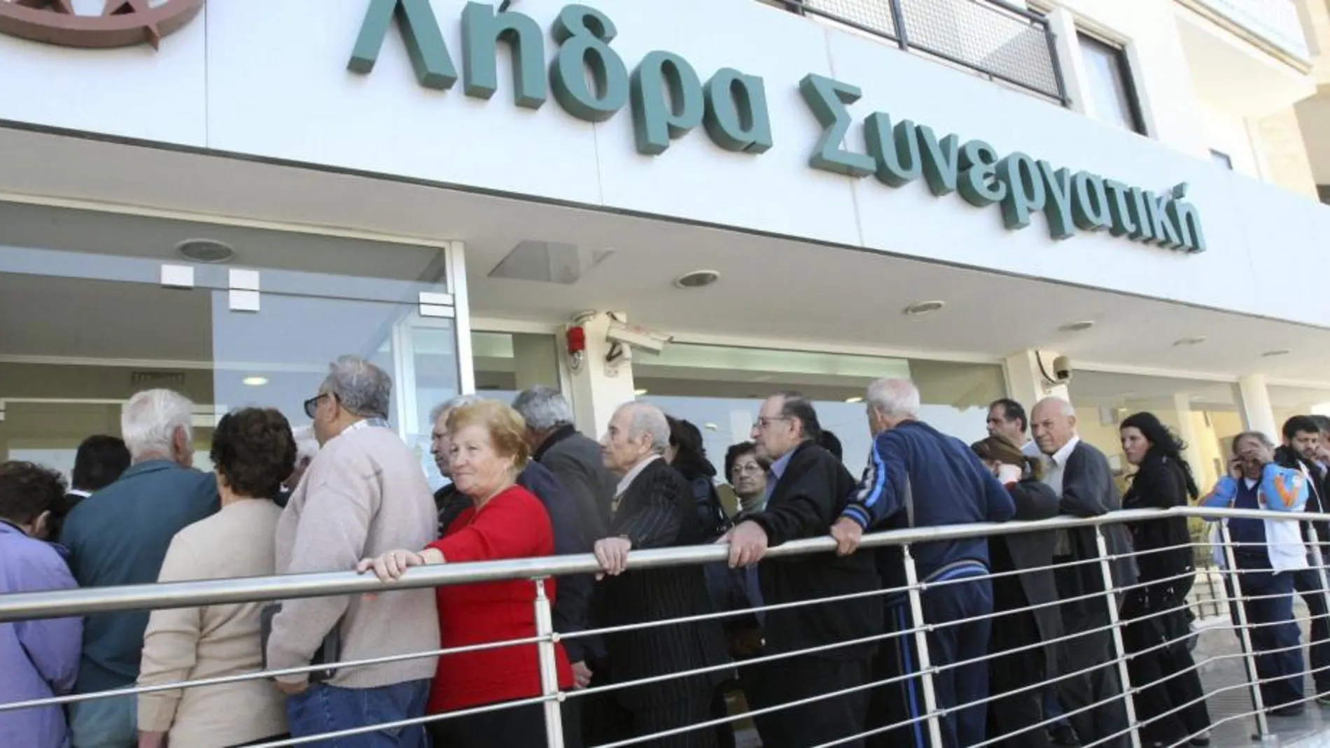 Chipriotas hacen cola para entrar en una sucursal del banco Coop, en Nicosia, hoy, jueves 28 de marzo