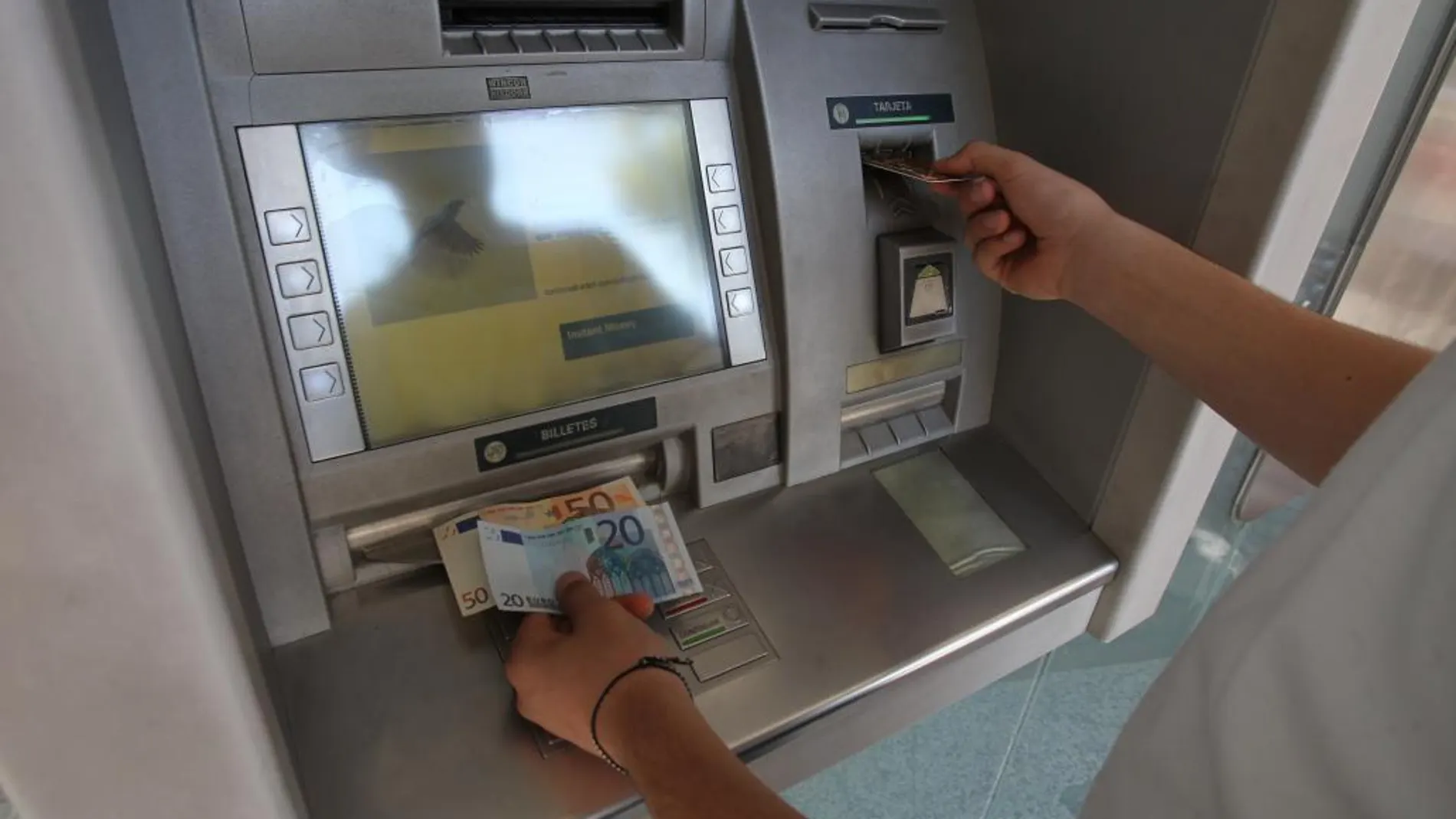 Imagen de una persona sacando dinero del banco