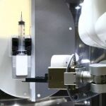 El robot de dos brazos mecánicos manipula jeringas y viales