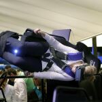 Una visitante prueba un simulador de vuelo acrobático de realidad virtual durante el Mobile World Congress (MWC)