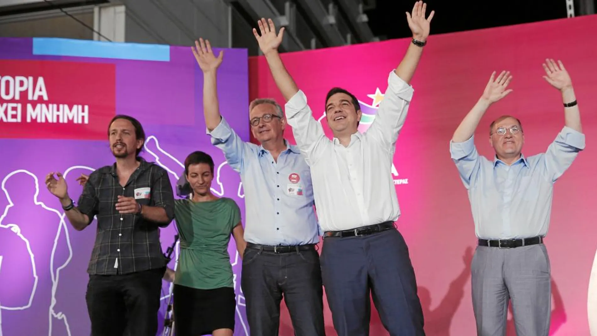 Tsipras saluda en el cierre de campaña arropado por el líder de Podemos, Pablo Iglesias, ayer en la plaza Sintagma de Atenas