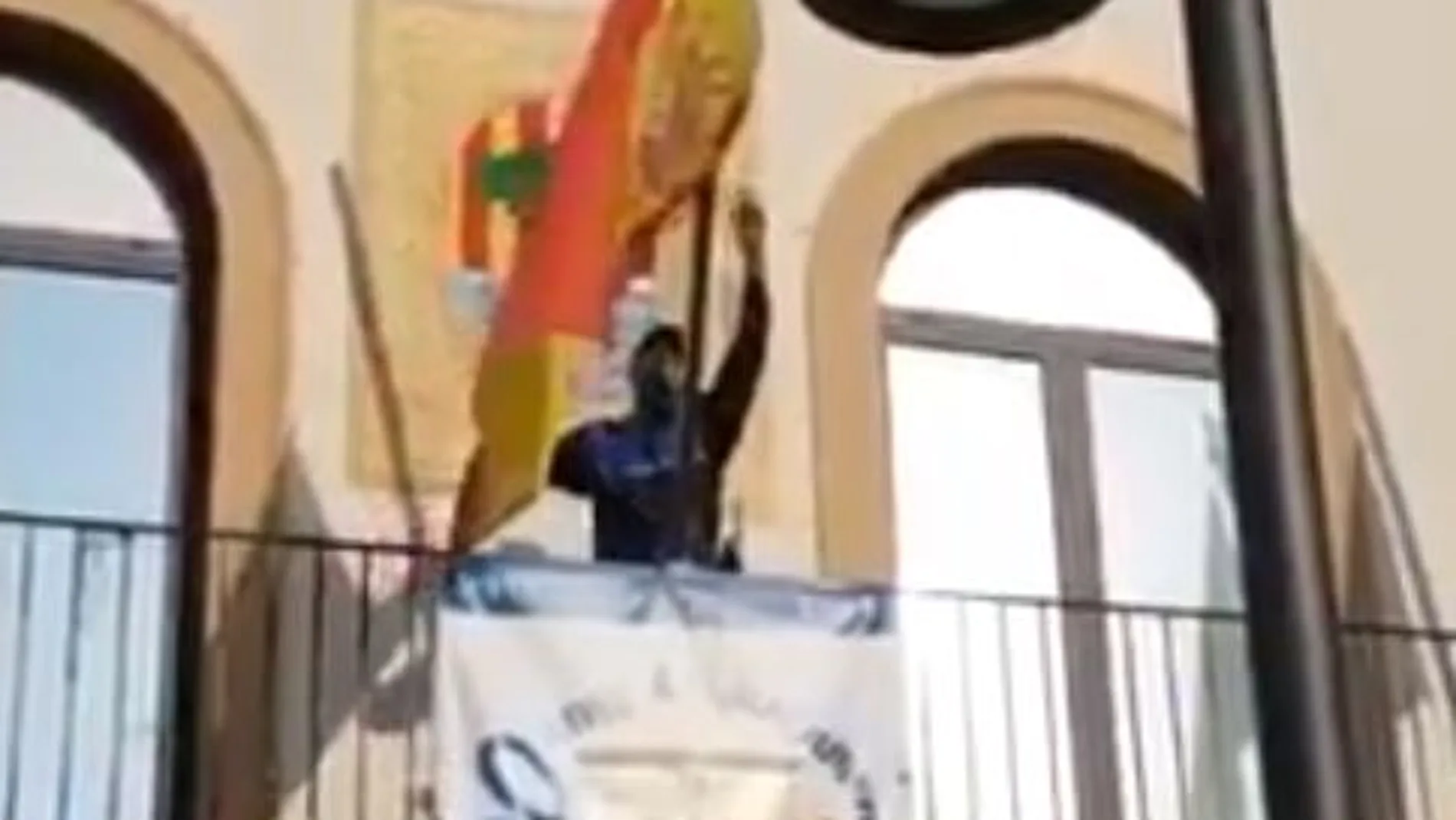 Un policía local de Pineda retira la bandera de España del balcón del Ayuntamiento