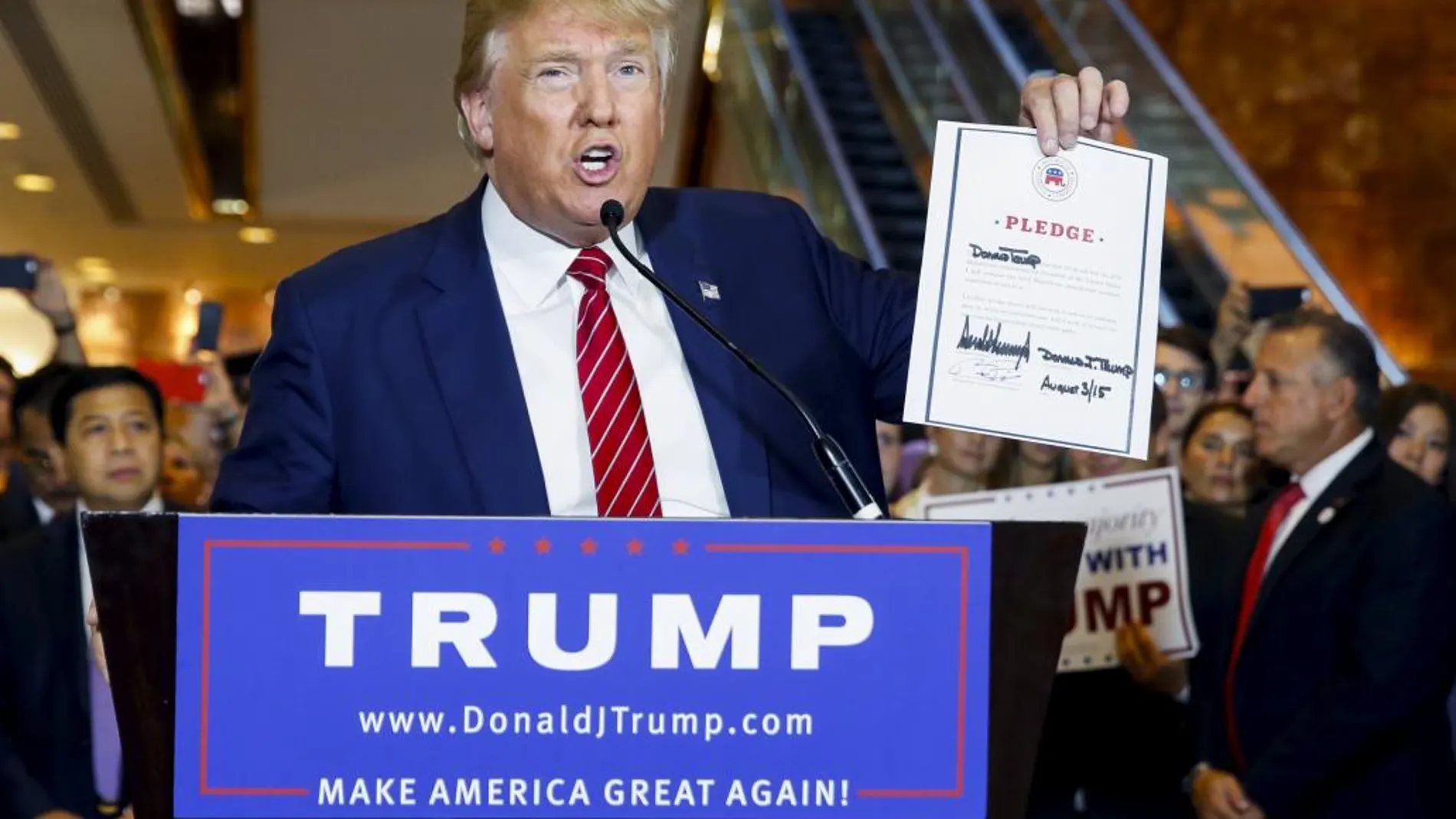 Donald Trump muestra el documento firmado por el cual se compromete a no presentarse a la casa Blanca como independiente si no es elegido por los replublicanos como candidato