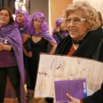 Un grupo de mujeres vestidas con «disfraces» de Podemos recibió ayer a la alcaldesa en Vallecas, donde mantuvo una charla con vecinos