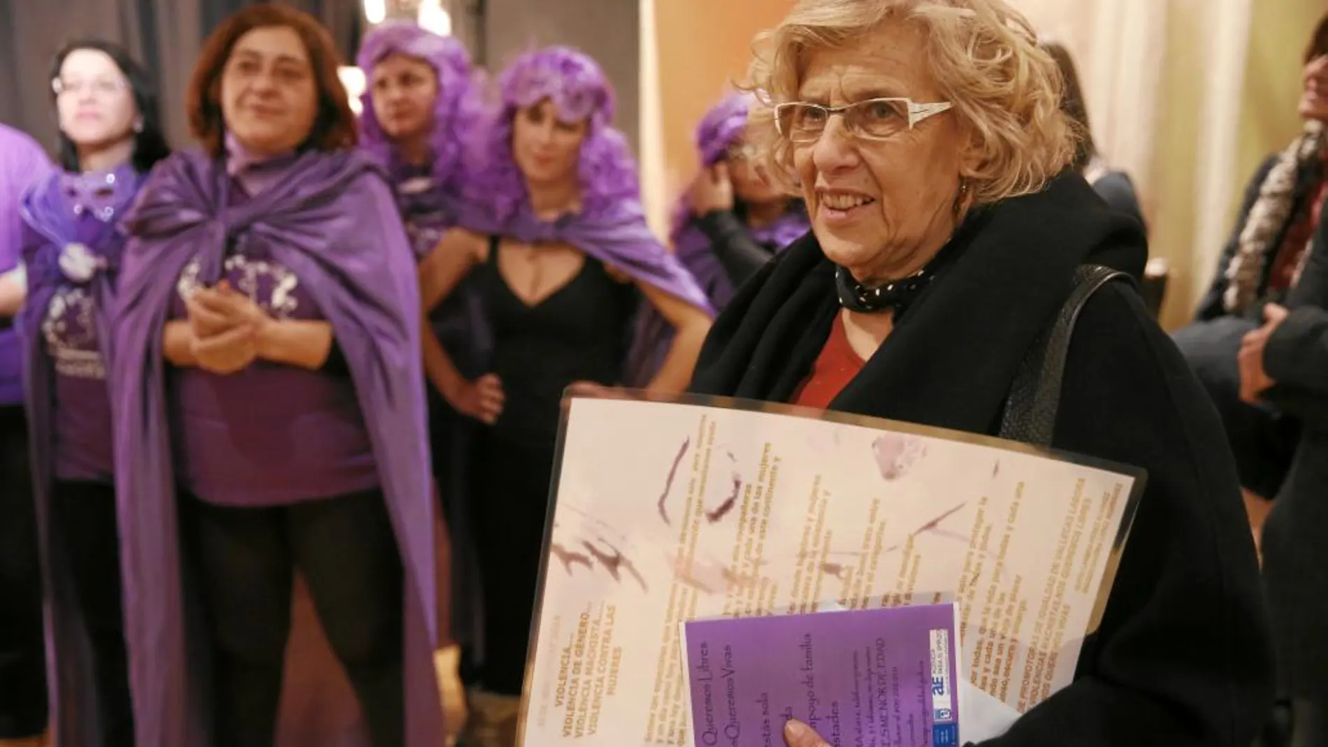 Un grupo de mujeres vestidas con «disfraces» de Podemos recibió ayer a la alcaldesa en Vallecas, donde mantuvo una charla con vecinos