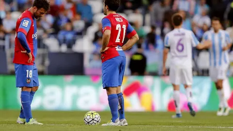 Los delanteros del Levante, Víctor Casadesús (i) y el italiano Giuseppe Rossi, esperan sacar del centro del campo tras encajar el primer gol del Málaga