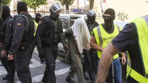 Miembros de la Guardia Civil custodian a uno de los tres hermanos pakistaníes detenidos en el barrio de Pardinyes