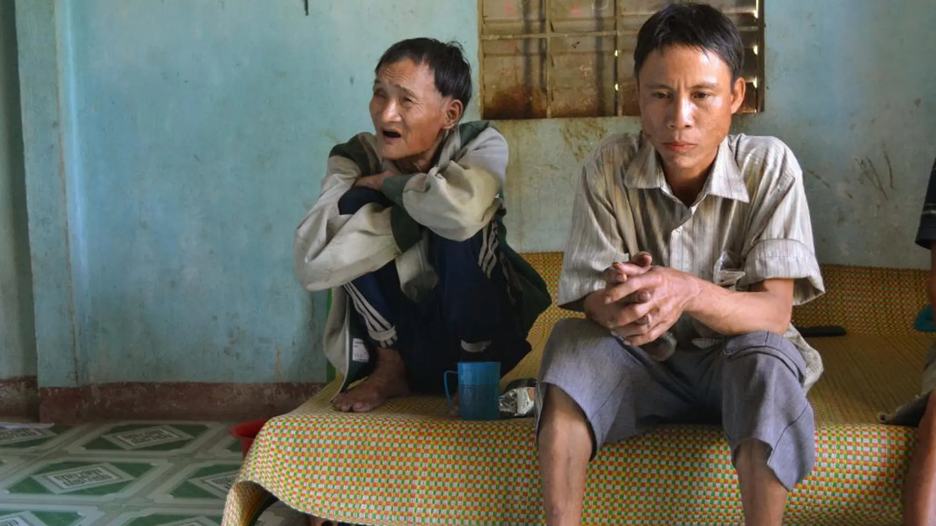 Ho Van Thanh (i), de 83 años, y su hijo Ho Van Lang (d), de 46, se adaptan con dificultades a su nueva vida en la aldea de Tay Tra