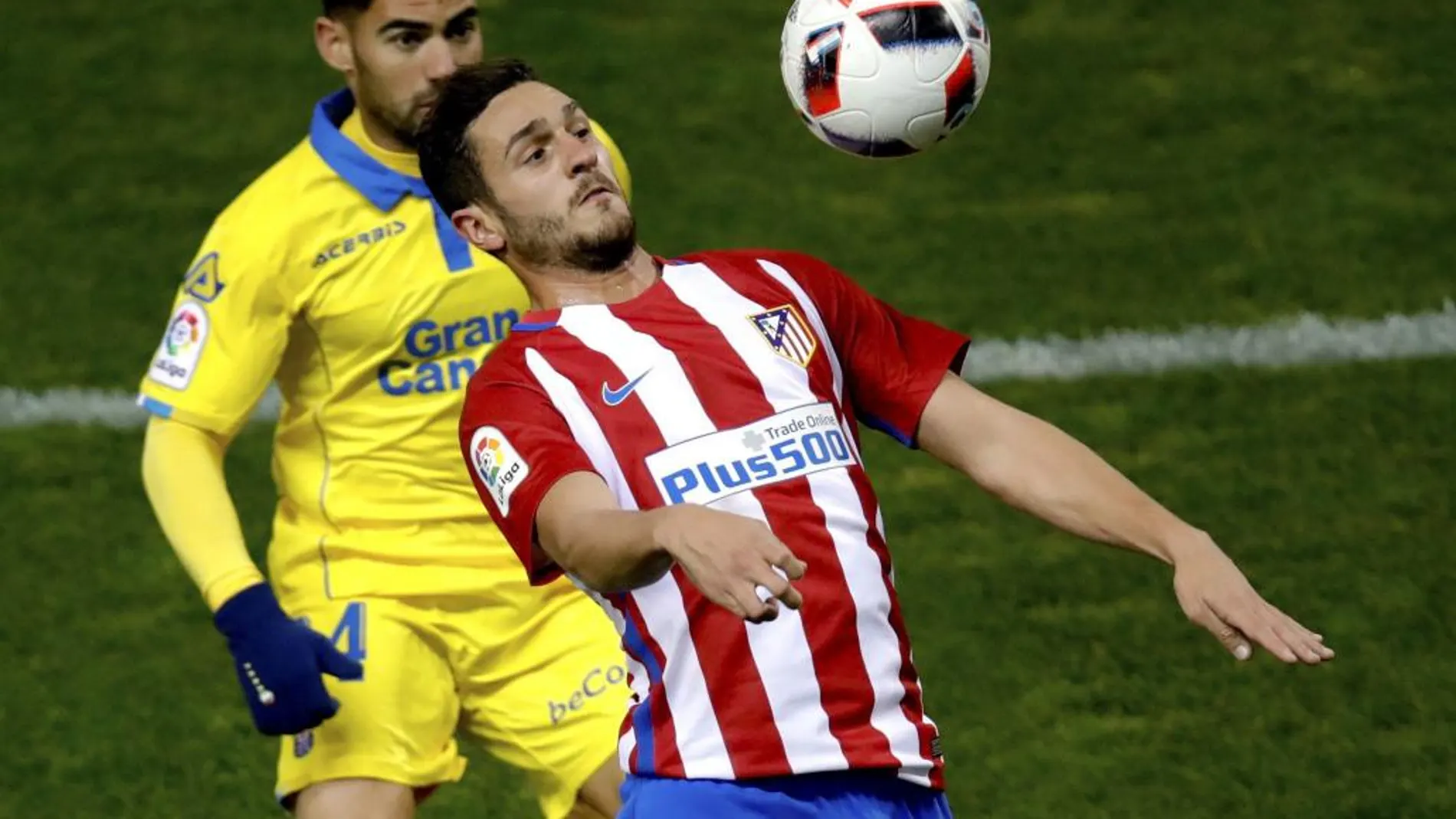 El centrocampista del Atlético de Madrid Koke Resurreción controla el balón junto a Pedro Tanausú "Tana", centrocampista de la UD Las Palmas
