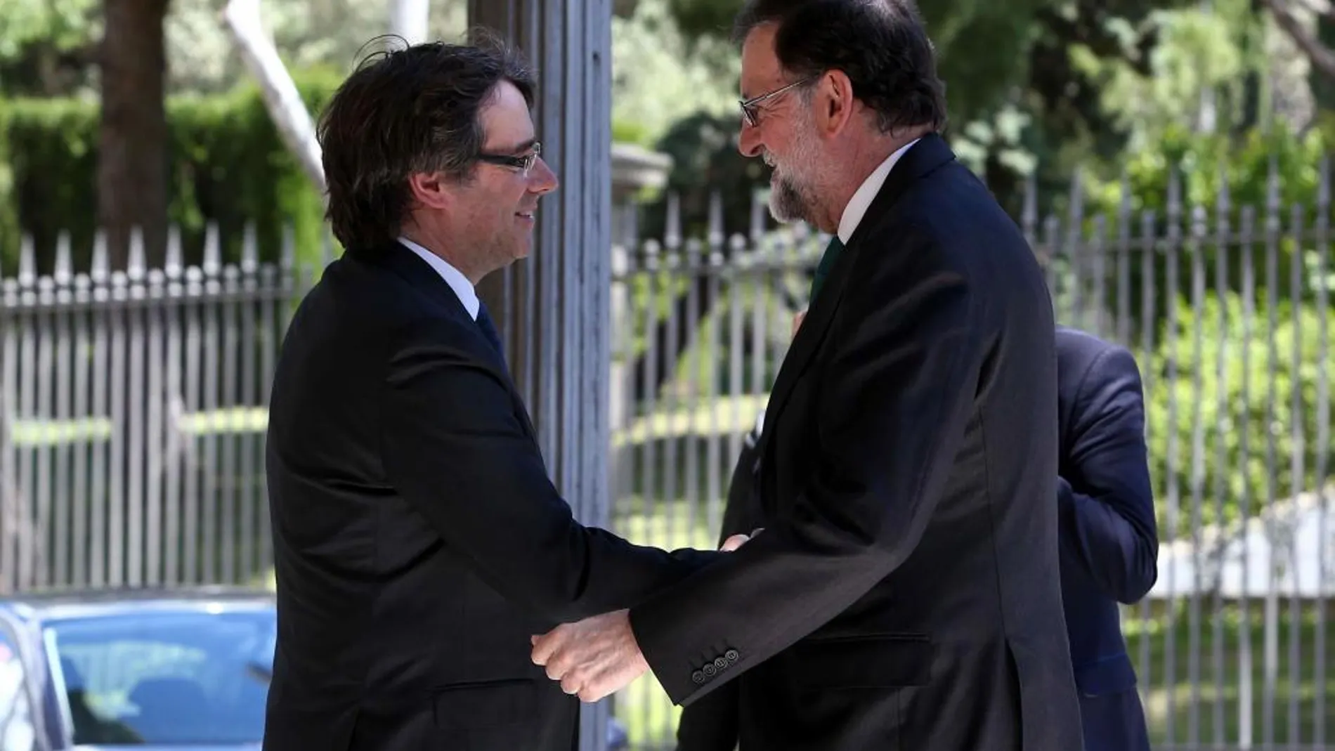 El presidente de la Generalitat, Carles Puigdemont (i), saluda al presidente del Gobierno, Mariano Rajoy (d), durante la inaguración del Automobile Barcelona.