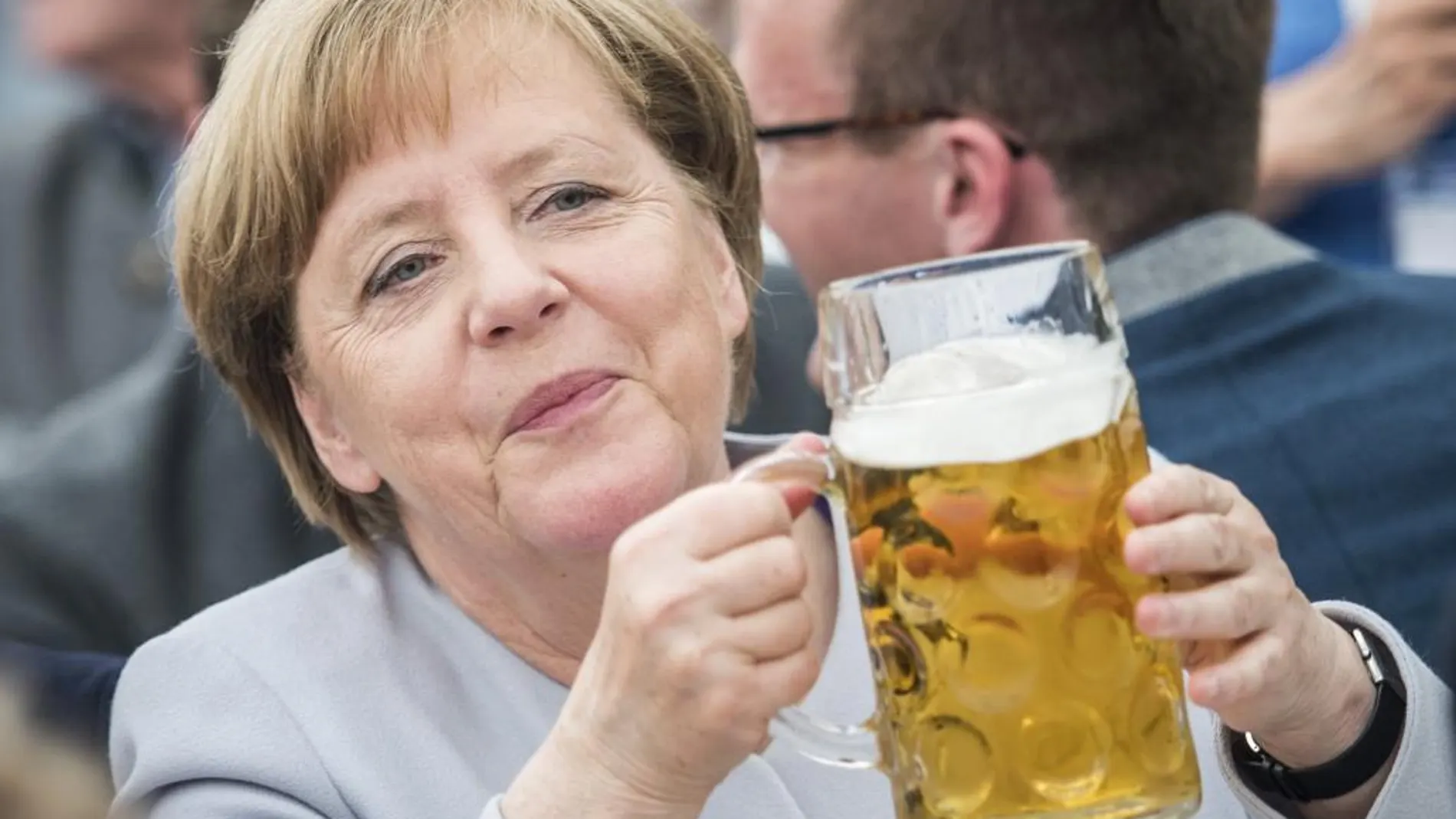 Angela Merkel sostiene una jarra de cerveza durante un acto electoral de la CDU en Múnich.