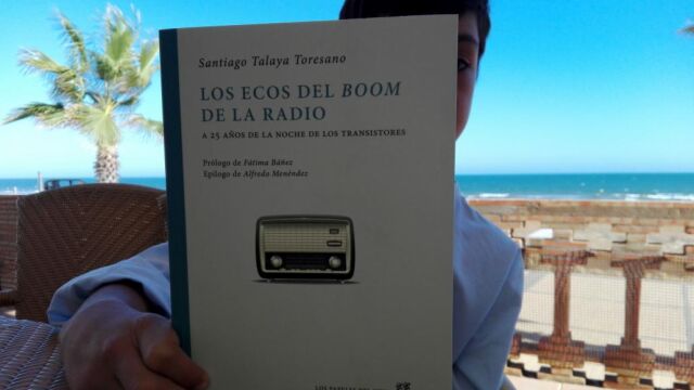 El hijo de Santiago Talaya muestra el libro de su padre, en su terraza de La Antilla (Lepe, Huelva)