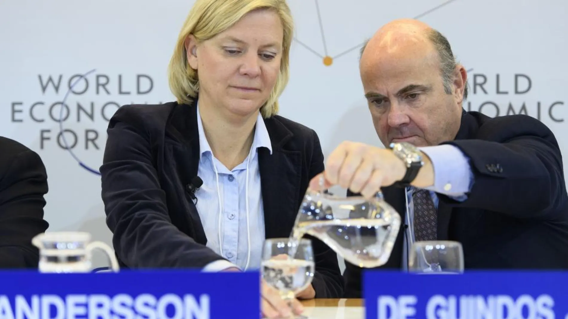 Luis de Guindos sirve agua a su homóloga sueca, Magdalena Andersson, durante la cumbre de Davos