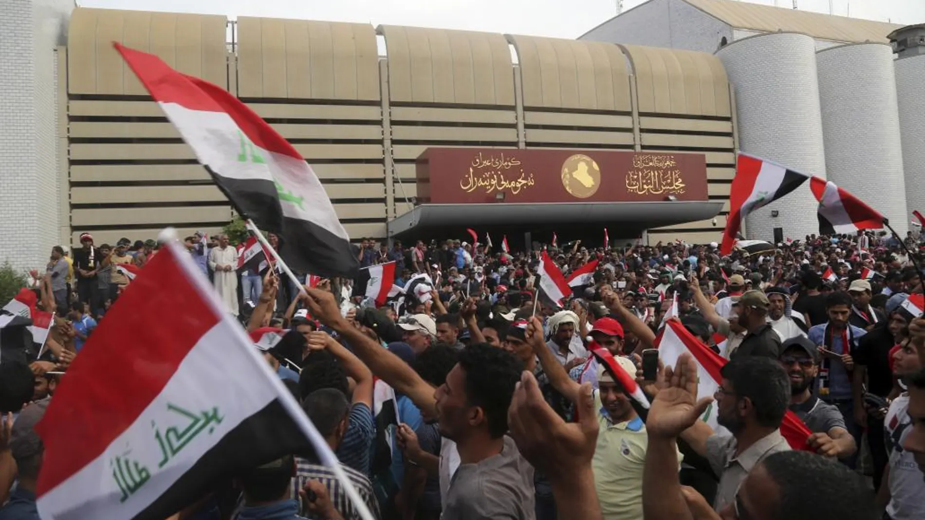 Seguidores del clérigo chií Muqtada al Sadr ondean banderas del país en la Zona Verde de Bagdad.