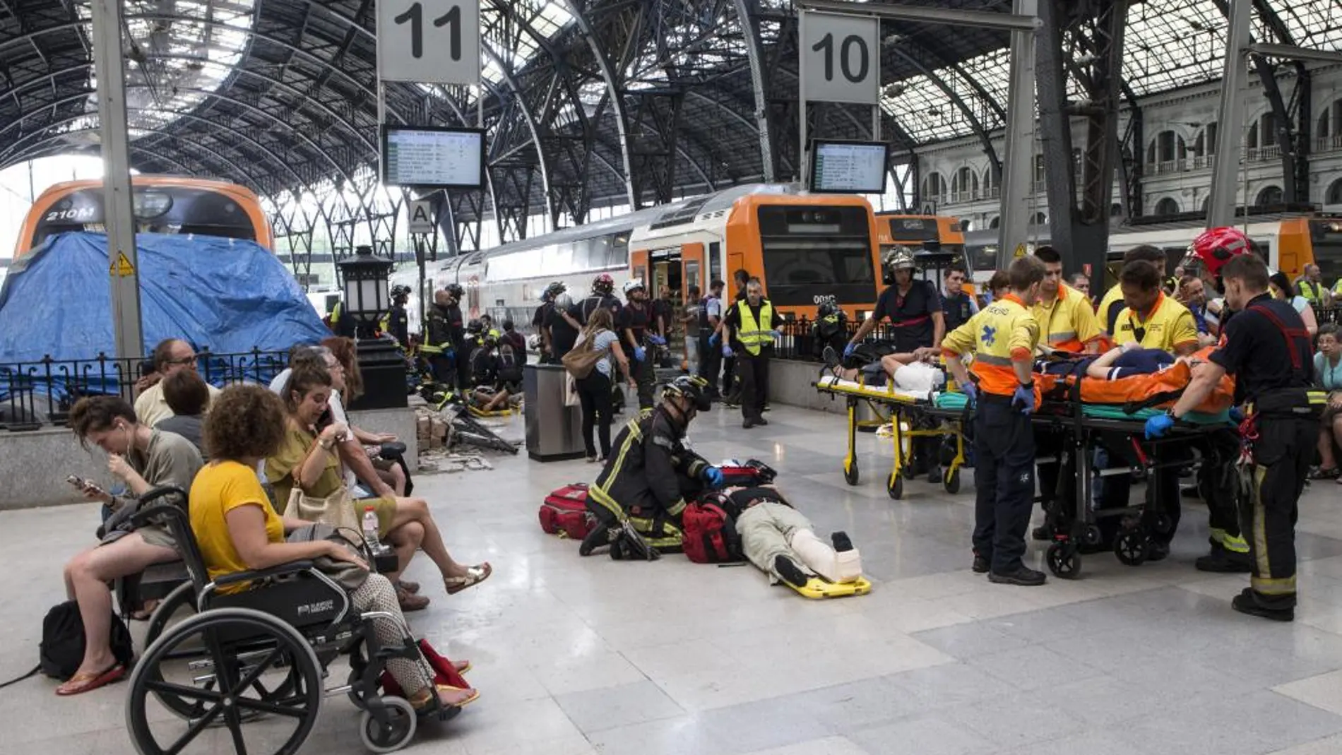 Equipos de emergencia atienden a los pasajeros que han resultado heridos al chocar un tren de Renfe contra el tope final de una vía en la Estación de Francia de Barcelona