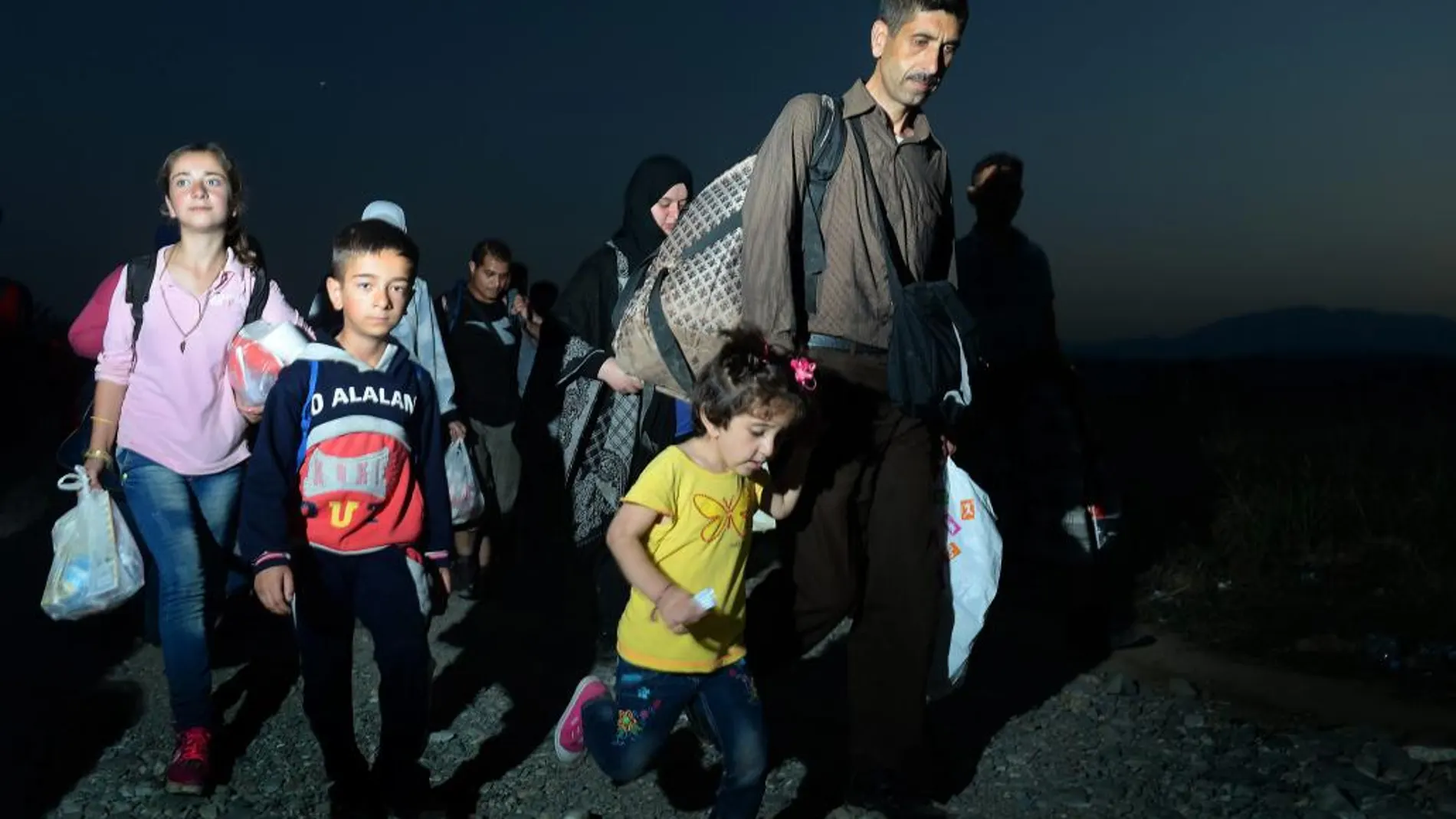 Una familia cruza la frontera entre Macedonia y Grecia en Gevgelija (Macedonia)