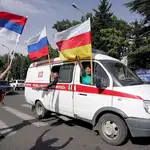 Ciudadanos osetios ondean las banderas de Osetia del Sur y Rusia.