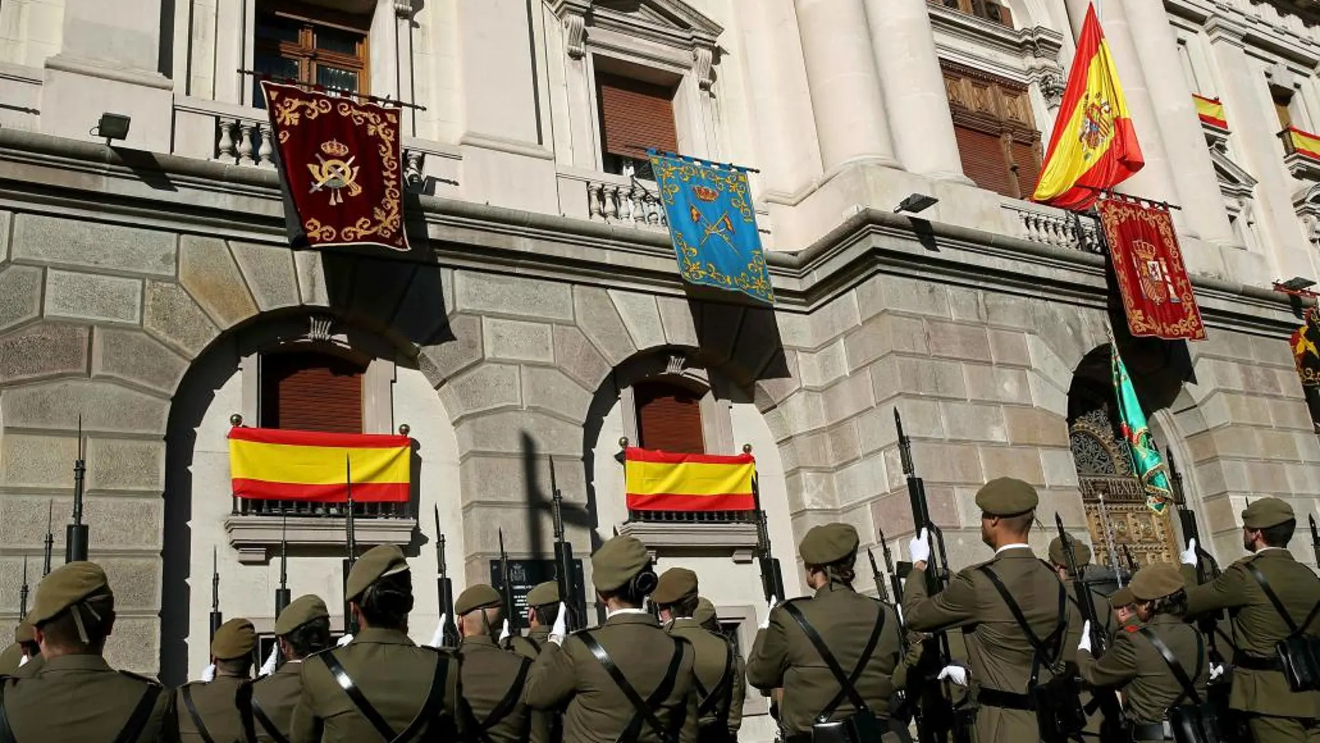Una formación del ejército rinde honores mientras se iza la bandera de España en el Palacio de Capitanía de Barcelona con motivo de la celebración de la Pascua Militar.
