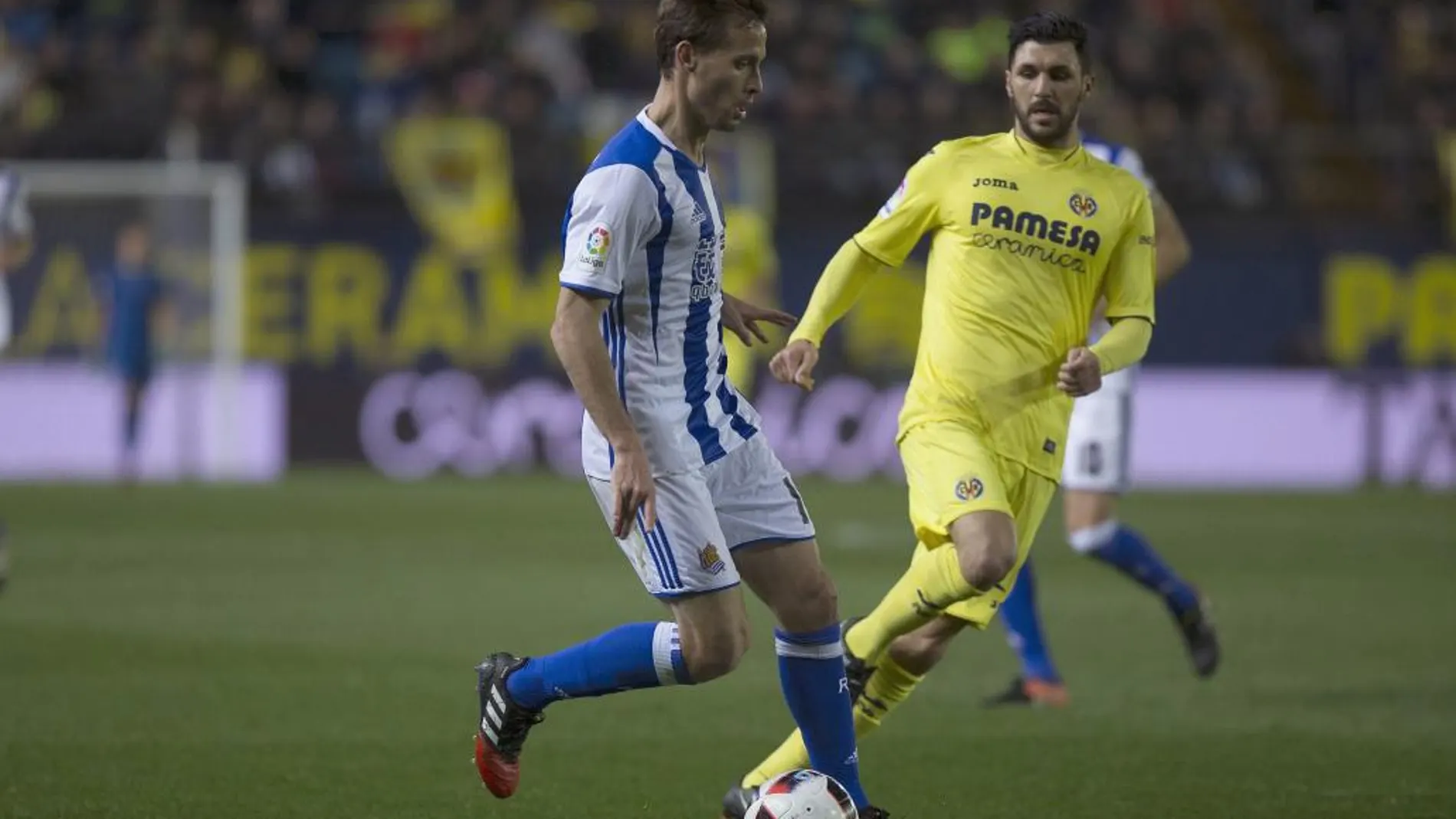 El centrocampista italiano del Villarreal Roberto Soriano (d) disputa un balón con el centrocampista de la Real Sociedad Sergio Canales (i), durante el partido