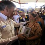El presidente de Colombia, Juan Manuel Santos, entrega una caja de ayuda humanitaria a una mujer deportada por Venezuela