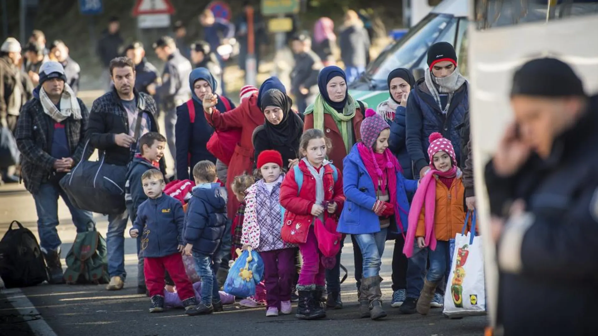 Un grupo de refugiados aguarda a subir al autobús en Wegscheid (Alemania)