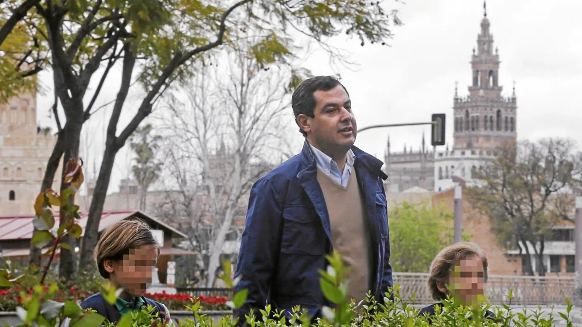 El presidente del PP-A, Juanma Moreno, pasea con sus dos hijos ayer en Sevilla