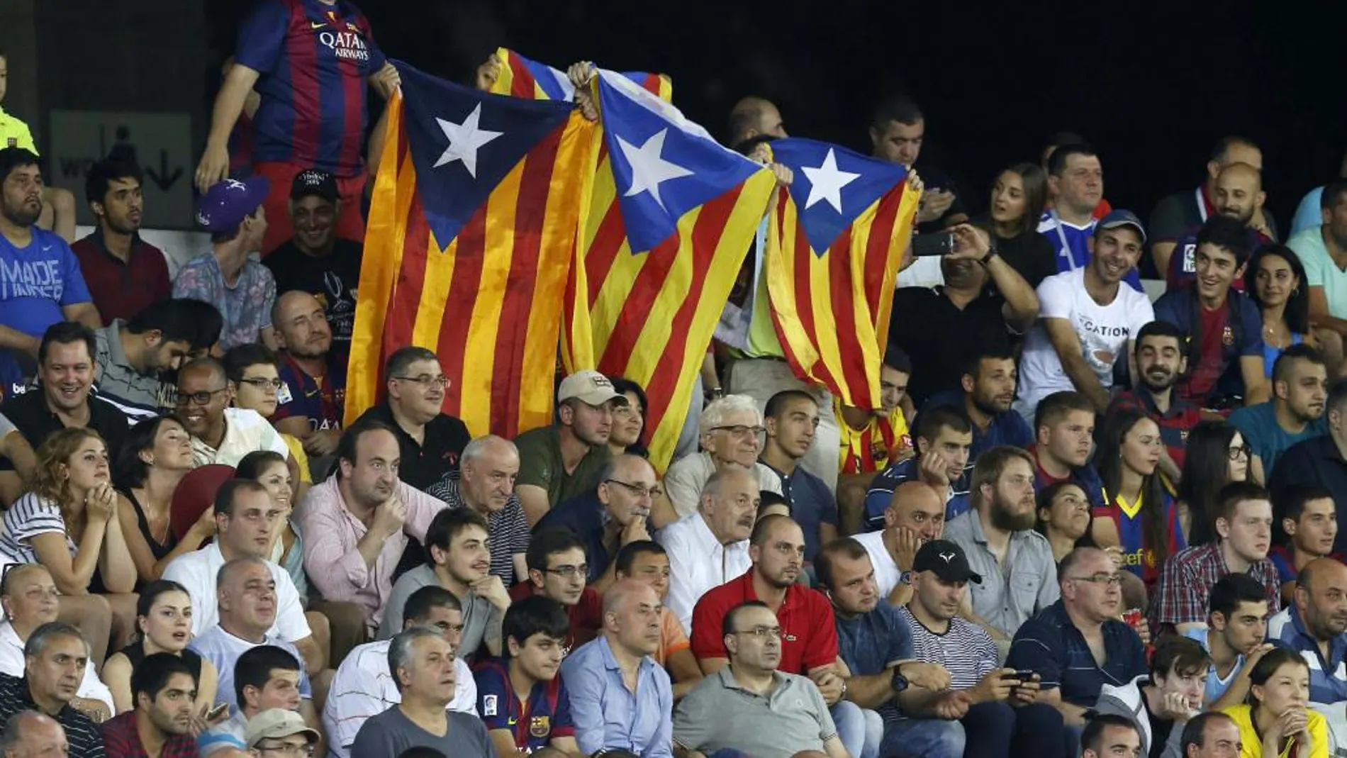 Aficionados del FC Barcelona despliegan unas «esteladas» (bandera independentista catalana) durante el partido de la Supercopa de Europa que se juega hoy en el estadio Boris Paichadze Dinamo Arena, en Tiflis (Georgia).
