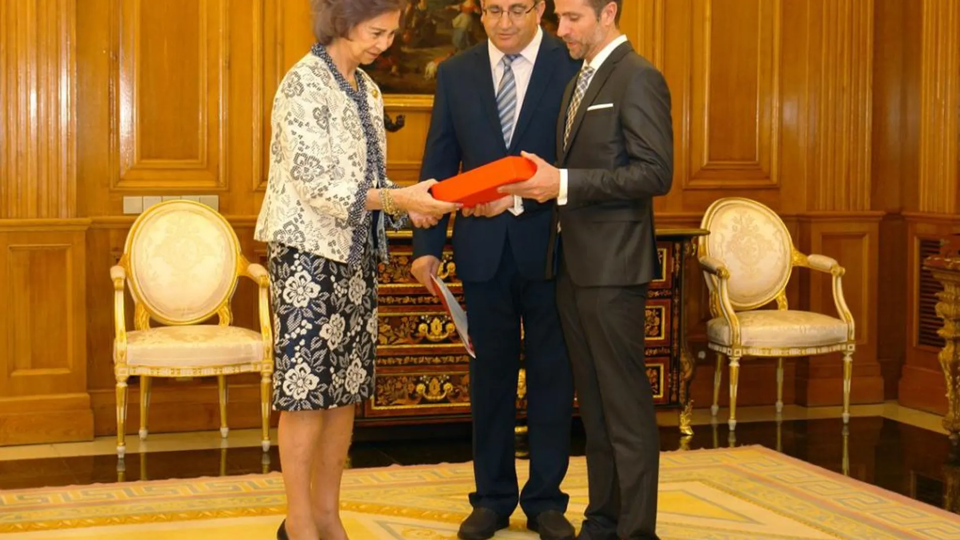 La Reina Emérita recibe el premio en el Palacio madrileño de manos del presidente de la organización en Castilla y León, Máximo Blanco Morán, y el secretario autonómico, Leandro Roldán Maza.