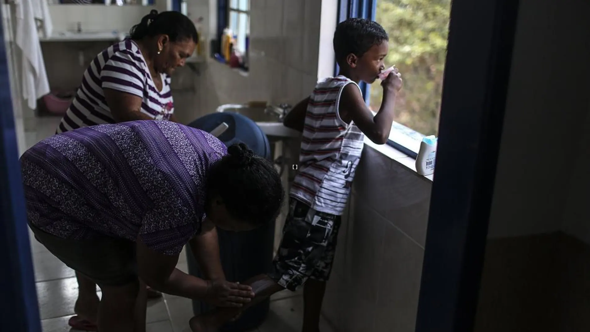 Un mujer cura a un niño en un hotel donde han sido alojados tras la riada