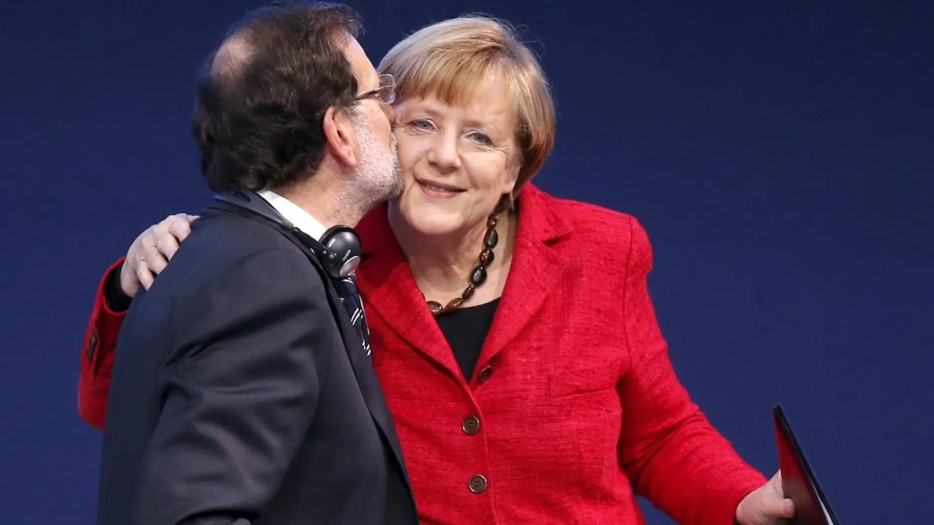 La canciller alemana, Angela Merkel, es felicitada por el presidente del Gobierno, Mariano Rajoy, tras su intervención