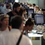 Personal de facturación de Vueling atiende a los viajeros en el Aeropuerto de El Prat