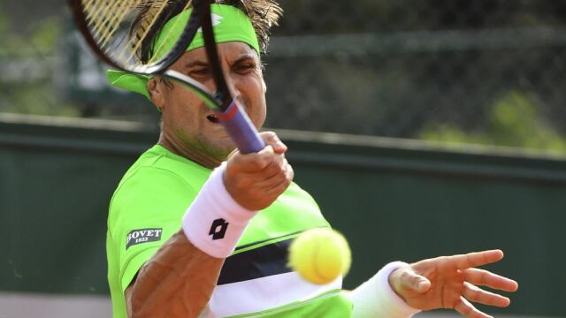 El tenista español David Ferrer devuelve la pelota al estadounidense Donald Young durante el partido de primera ronda de Roland Garros